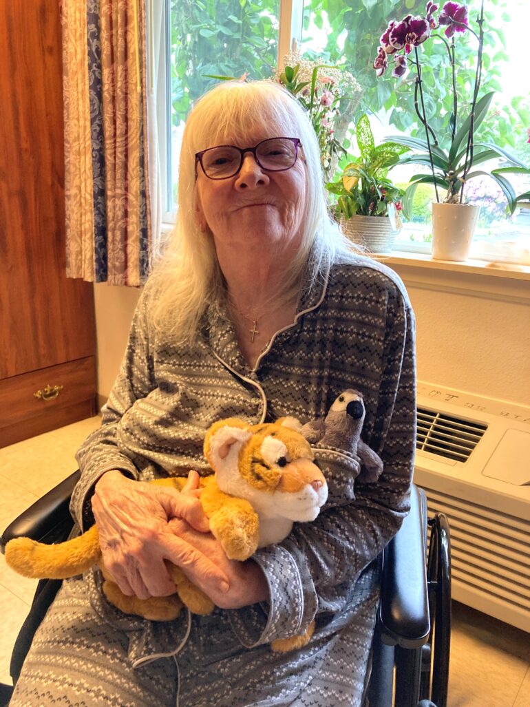resident Candy B. sitting with her stuffed animal.
