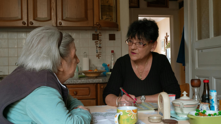 a caregiver sitting with a loved one